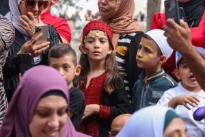 Palestinian children dressed in traditional clothing watch the scounts' parade in the Old City of occupied East Jerusalem, Saturday 8 October 2022. [Source: Ramallah News]